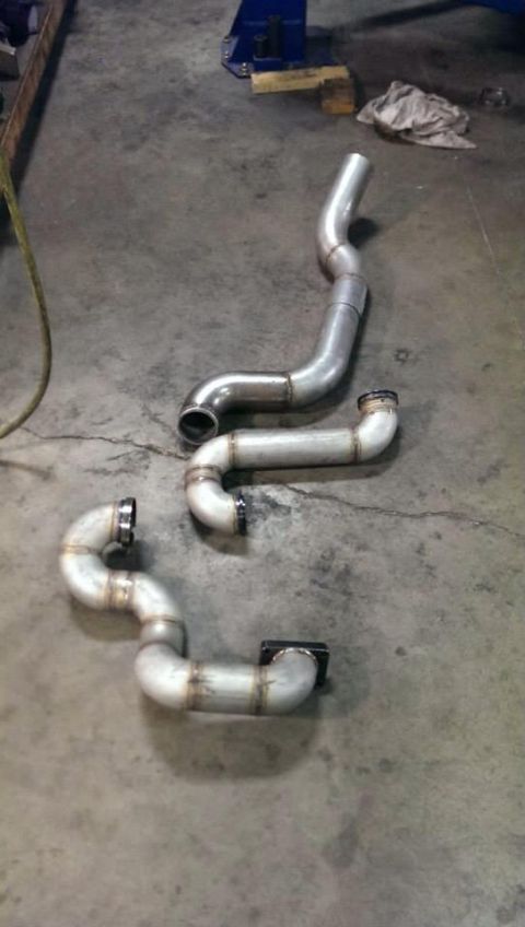 1995 Ford Bronco - Custom exhaust pipes are laid out on a workshop floor.