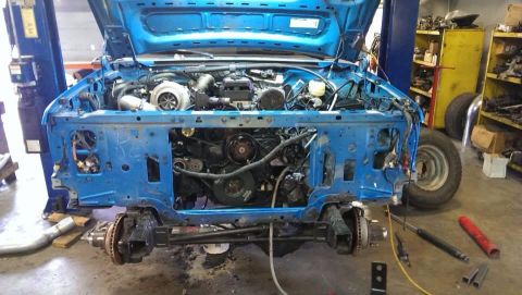 1995 Ford Bronco - Truck body in shop, front end disassembled for engine work. Turbocharger visible in engine bay.