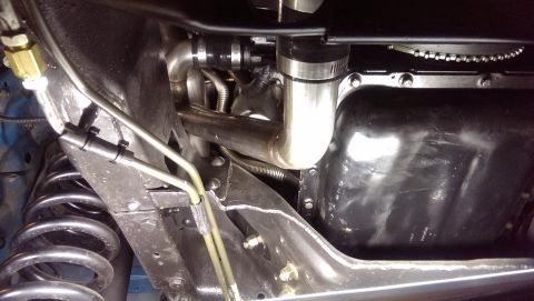1995 Ford Bronco - Close-up view of the underbody, showing custom exhaust components and the oil pan.