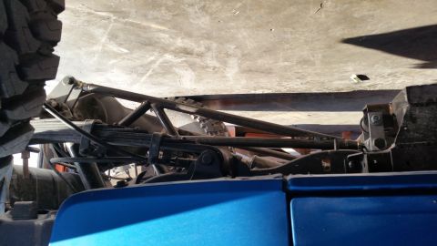 1995 Ford Bronco - This photo shows the modified rear suspension and axle assembly of a vehicle, with a large tire in the foreground.