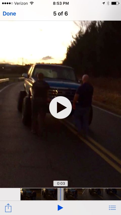 1995 Ford Bronco - A blue pickup truck is parked on the side of a road during sunset.
