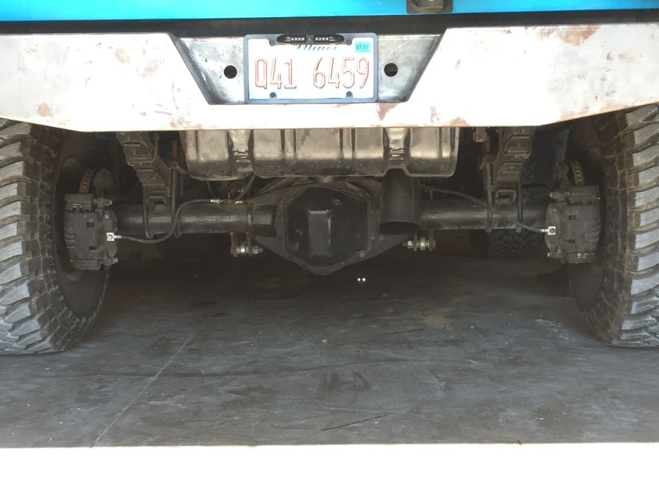 Rear axle, leaf springs, and tires of a truck with a license plate reading 041 6459