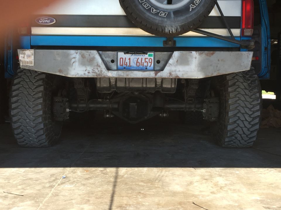 Rear of a blue 1992 Ford Bronco with a custom metal bumper and large off-road tires