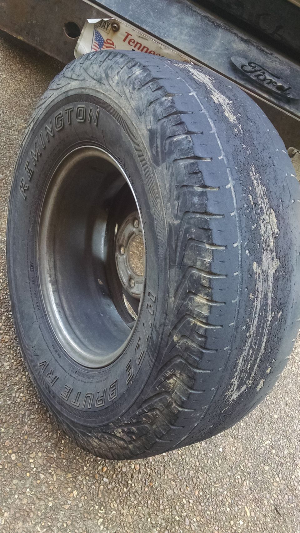 Worn Remington "Brute" tire on a Ford truck, with a Tennessee license plate visible