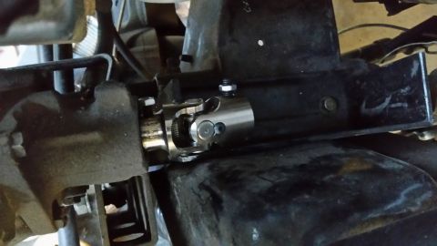 1979 Ford Bronco - A close-up view shows a silver steering shaft universal joint, also known as a U-joint, installed on a vehicle's steering column. The U-joi…