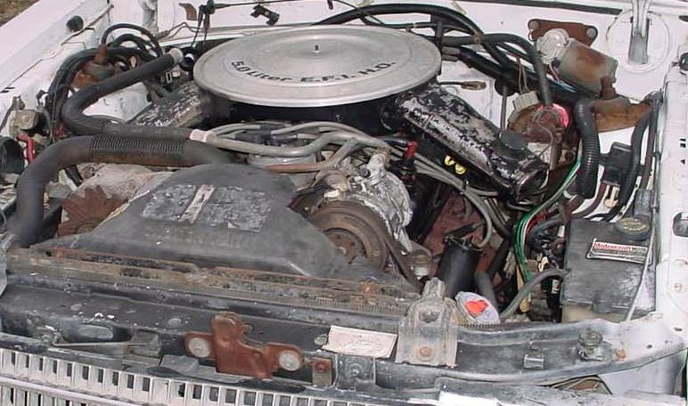 Engine bay of white Ford LTD with 5.0 Liter EFI H.O. air cleaner and Motorcraft battery
