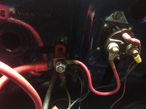 1982 Ford Bronco - Close-up view of automotive electrical connections, including a starter solenoid and heavy gauge red wiring, mounted to a dark blue painted…