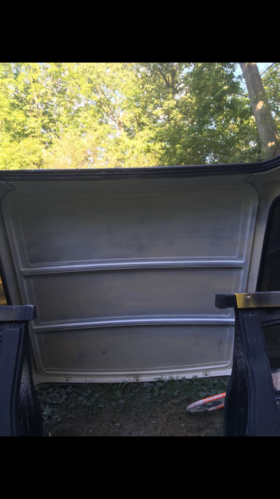 Interior of a vehicle's cargo area with light gray paneling and horizontal trim.
