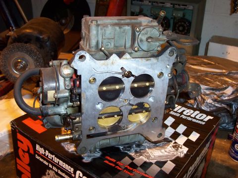 1994 Ford Bronco - A Holley carburetor sits on its product box, with a grinding tool visible behind it.