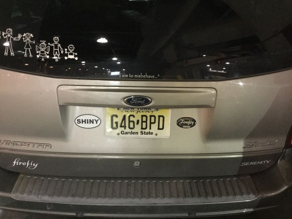 Rear of a silver Ford Windstar minivan with NJ license plate and various stickers.