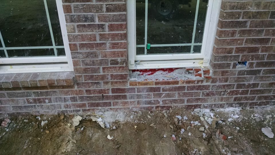 The masonry contractor was cleaning up and ripped out a window ledge, damaged some Aluminum trim, and broke my hose splitter. North wall of garage looking south.