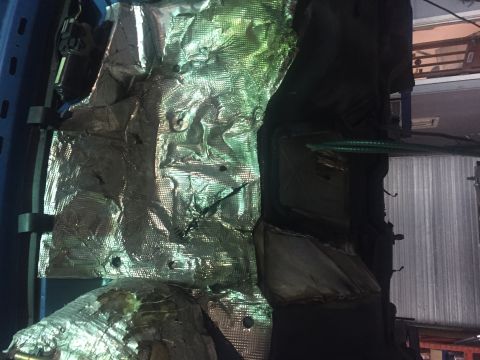 1995 Ford Bronco - A close-up view of the undercarriage of a vehicle, showing silver heat shielding material attached to a dark, possibly rubberized, componen…