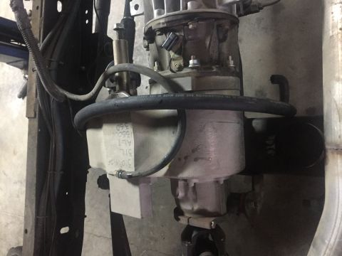 1995 Ford Bronco - A close-up view of a transmission fluid reservoir and associated hoses mounted on a vehicle. Text on the reservoir indicates "ALT 31L 13500…