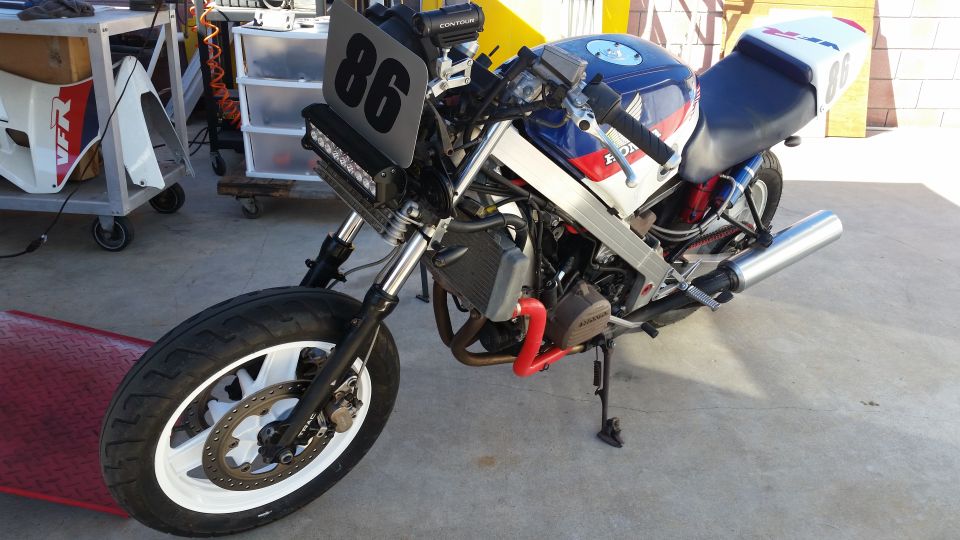 Custom motorcycle with race number 86, blue white red paint, aftermarket exhaust