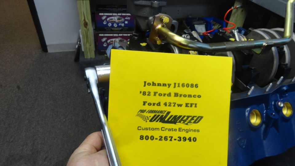 Yellow card with engine details in front of a blue engine block.