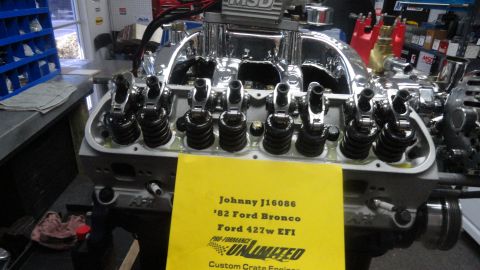 1982 Ford Bronco - A close-up view of a Ford 427w EFI engine with a yellow sign in front of it. The sign reads "Johnny J16086 '82 Ford Bronco Ford 427w EFI Pr…