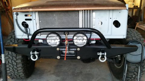 1979 Ford Bronco - Front view of a custom off-road bumper on a classic Ford Bronco. The bumper features a winch, two PIAA driving lights, and D-ring recovery…