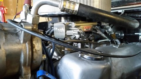 1979 Ford Bronco - A close-up view of a modified engine bay shows a Holley carburetor with a "Go Street" decal and various hoses and wiring. The engine compon…