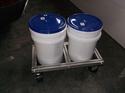1999 Mercury Grand Marquis - Two white five-gallon buckets with blue lids sit on a metal cart with wheels. The buckets appear to contain a light-colored liquid or powde…