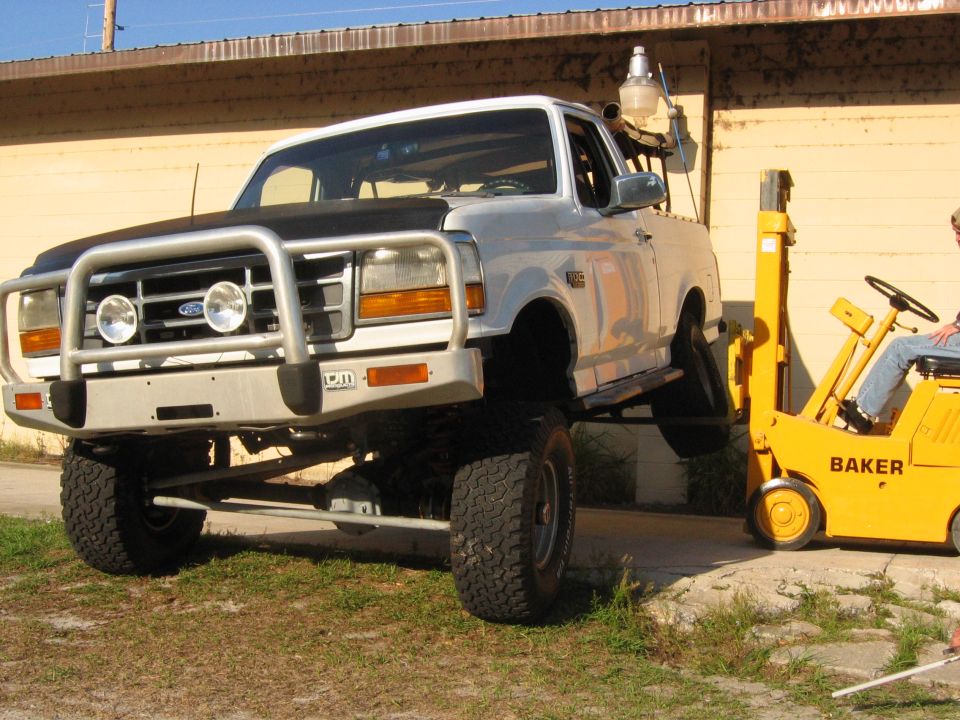 Silver 1992 Ford Bronco with a bull bar and large tires, viewed from the front-right