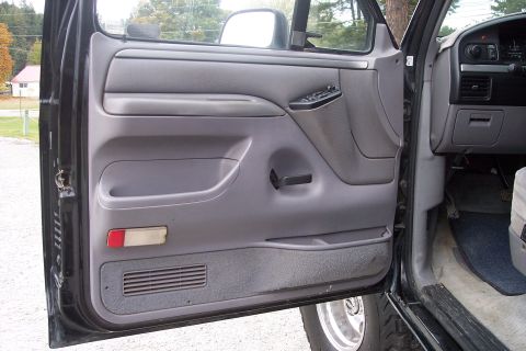1995 Ford Bronco - Interior view of a 1995 Ford Bronco, focusing on the driver's side door panel and dashboard.