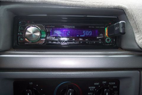 1995 Ford Bronco - Close-up of a car's dashboard showing a Kenwood stereo system with a USB drive inserted.