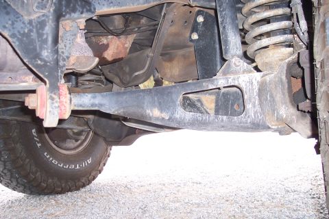 1995 Ford Bronco - Close-up view of the undercarriage, focusing on the suspension system and a tire.