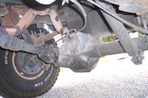 1995 Ford Bronco - Close-up of the rear axle assembly and exhaust pipe on a vehicle.