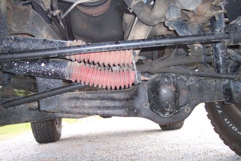1995 Ford Bronco - Close-up of the front axle and steering linkage on a vehicle.