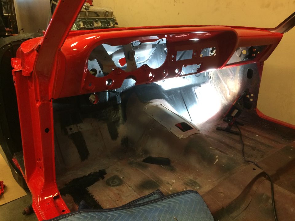 1964 Ford Fairlane interior showing red painted dashboard and bare floor panels