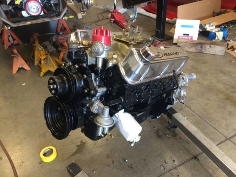 1964 Ford Fairlane - V8 engine with chrome valve covers and red distributor cap on an engine stand.
