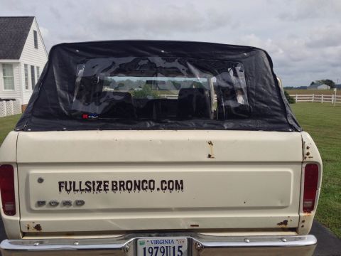 1979 Ford Bronco - This 1979 Ford Bronco features a black soft top and a prominent website decal on its tailgate.