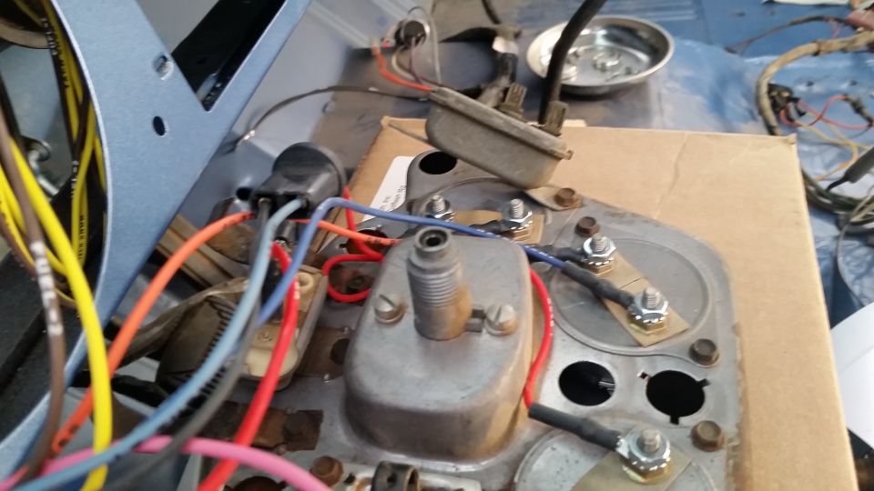 Disassembled gauge cluster wiring with coil and colored wires on cardboard