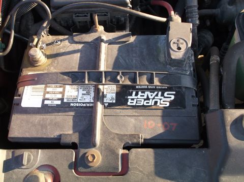 1999 Mercury Grand Marquis - A close-up view of a Super Start car battery in an engine bay. The battery has a date stamp of "10-07" visible in red marker.