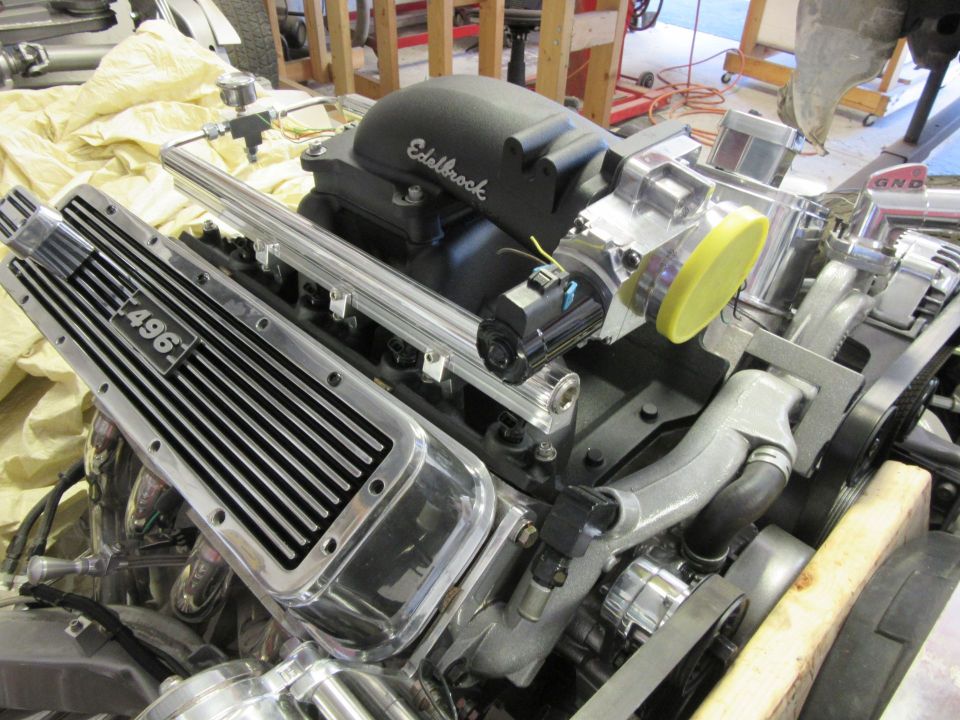 Custom V8 engine with chrome valve cover labeled "496" and Edelbrock intake.