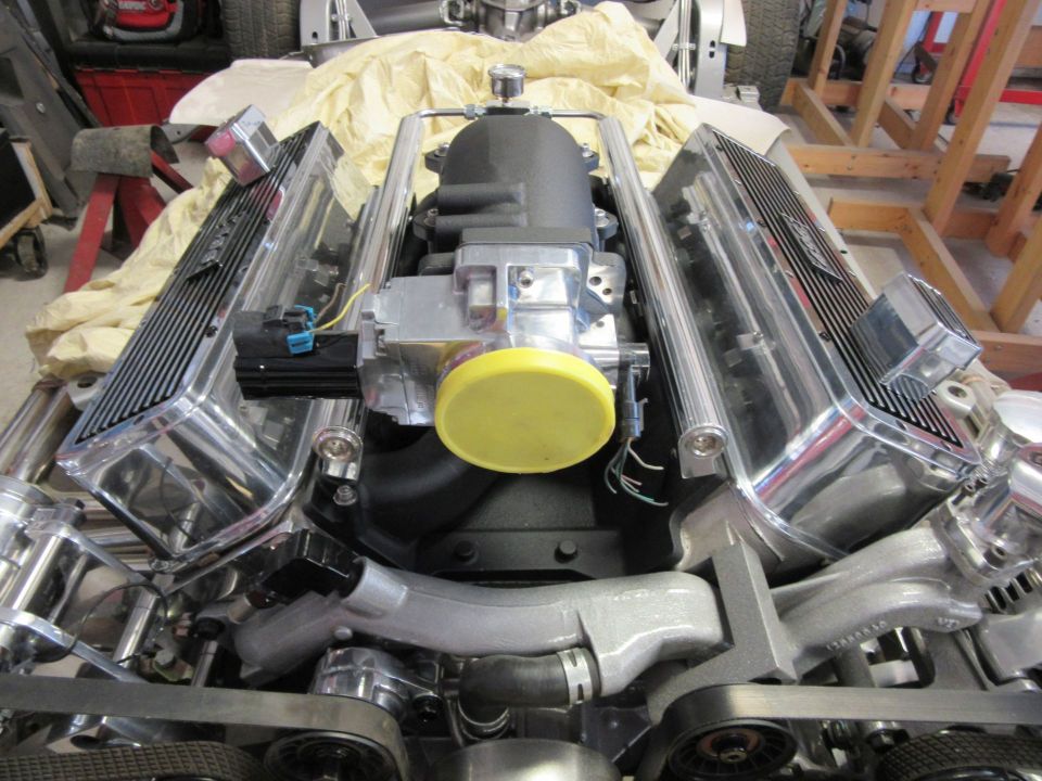 Chrome V8 engine with black intake and yellow cap