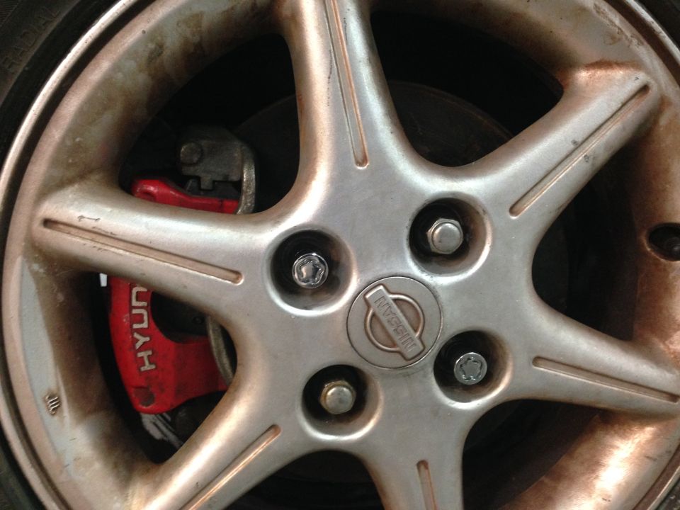 Silver Nissan wheel with red brake caliper