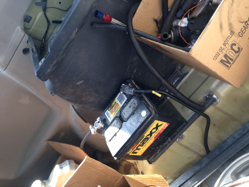 Car battery mounted in trunk with hoses and box of parts