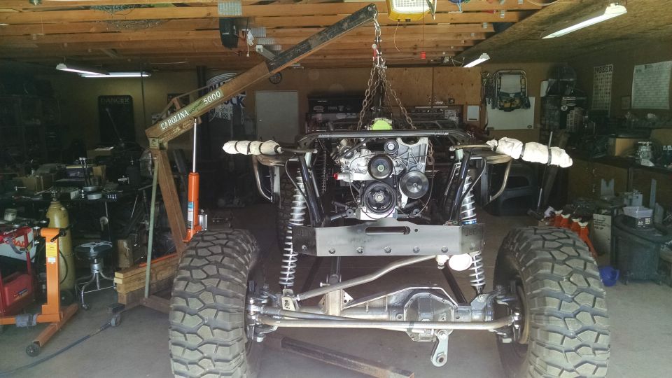 Custom Jeep CJ7 with engine being installed in a garage.