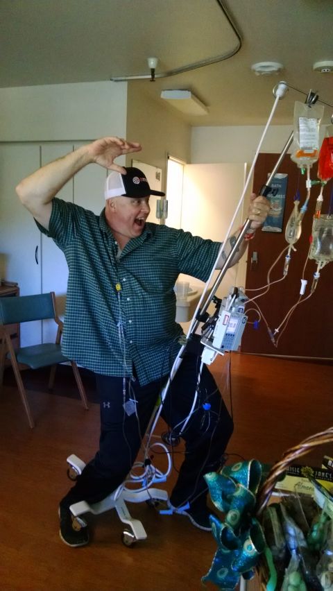 1985 Jeep CJ7 - A man wearing a plaid shirt and a baseball cap is posing with medical equipment in what appears to be a hospital room.