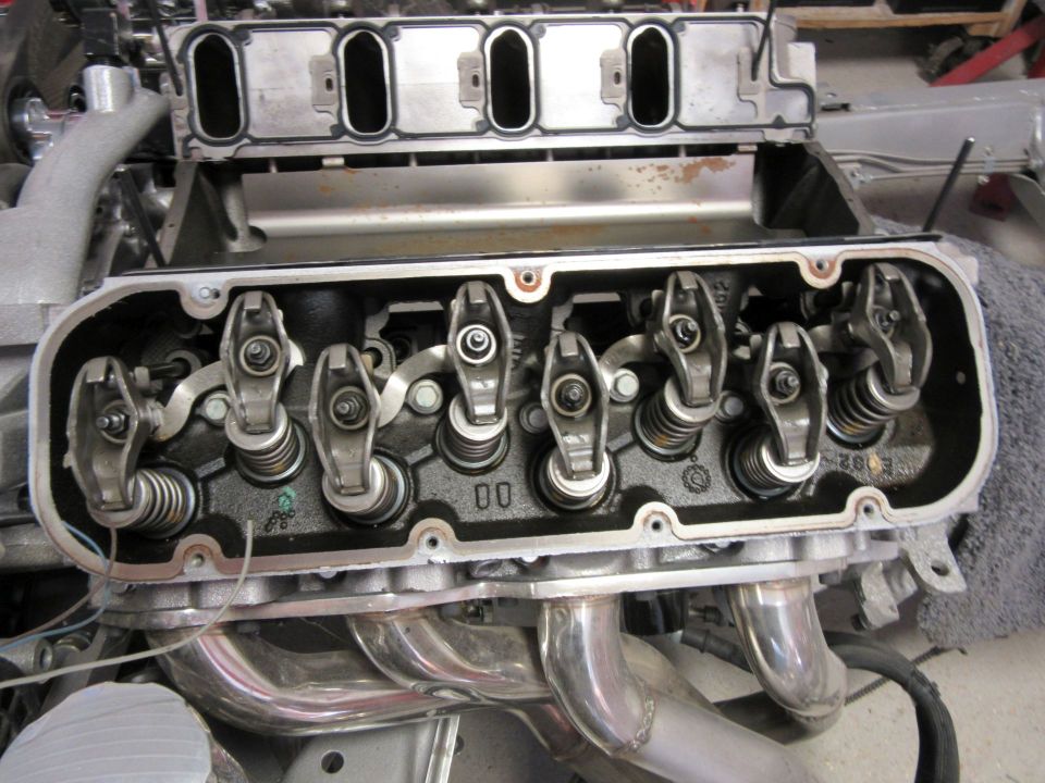 Internal view of a V8 engine cylinder head with rocker arms and valve springs.