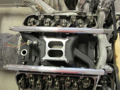 Close-up of a V8 engine intake manifold with chrome fuel rails.
