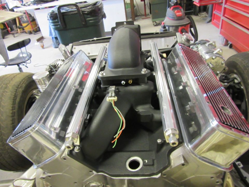 Overhead view of a V8 engine with polished valve covers and black intake manifold.