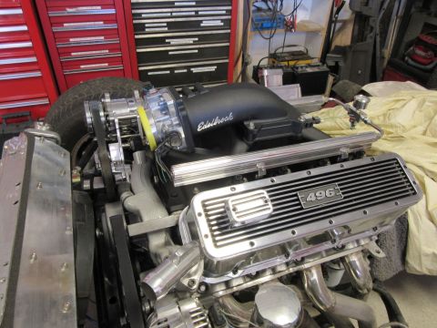 Close-up of a V8 engine with Edelbrock intake and "496" chrome valve covers.