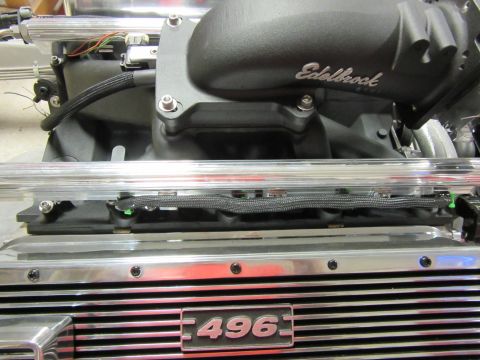 Close-up of a vehicle engine intake manifold with Edelbrock logo and '496' emblem.