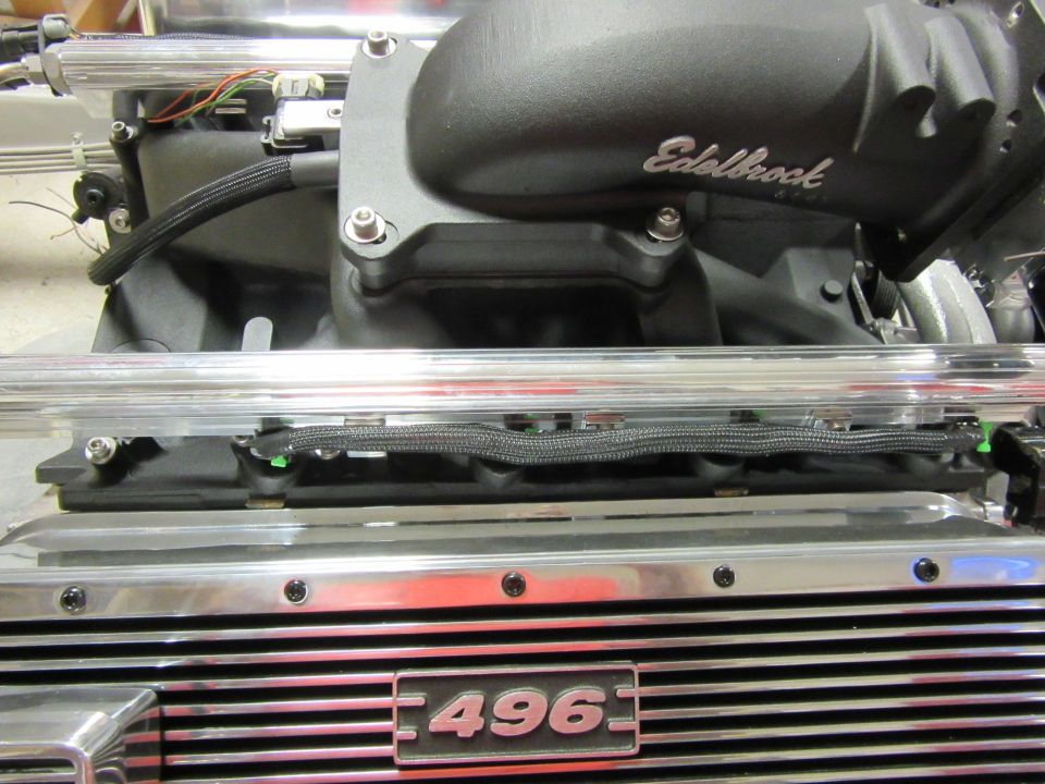 Close-up of a vehicle engine intake manifold with Edelbrock logo and '496' emblem.