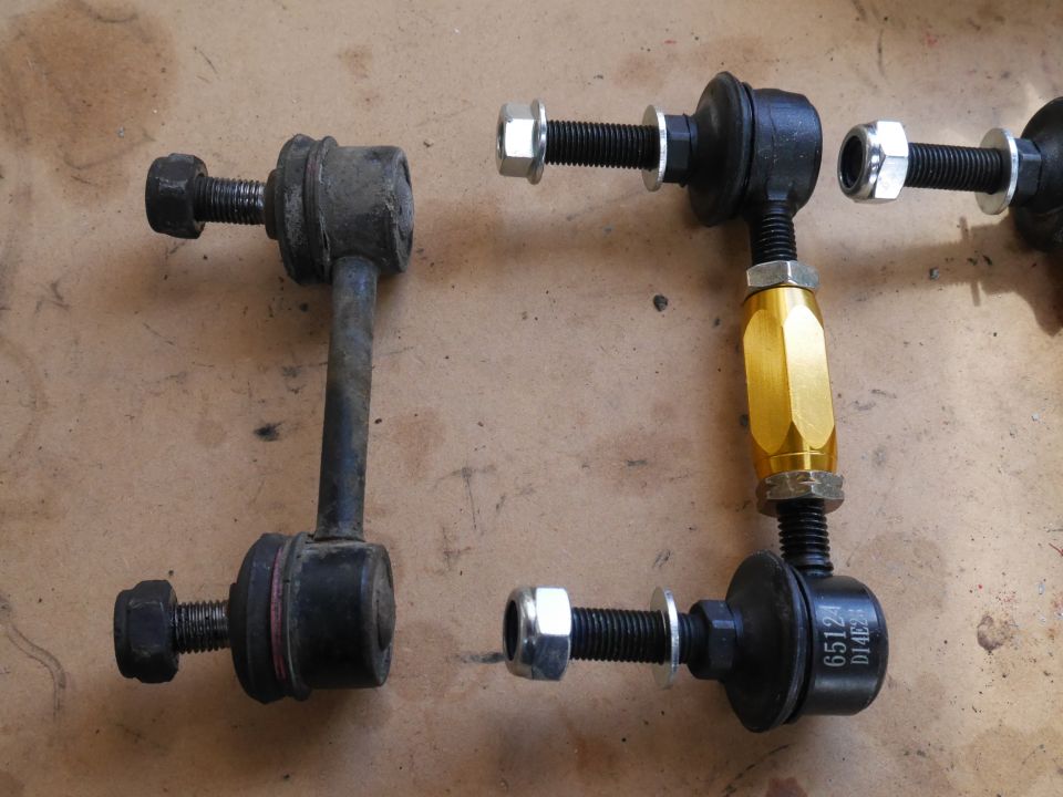 Two sets of adjustable sway bar end links, one old steel, one new with gold adjuster.