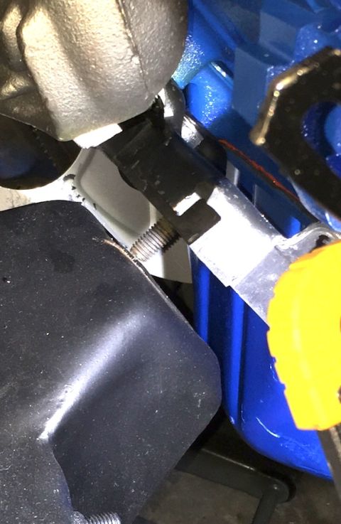 1978 Ford Bronco - A close-up view shows a threaded bolt secured to a black component, with a bright blue metal part and a yellow plastic piece visible in the…