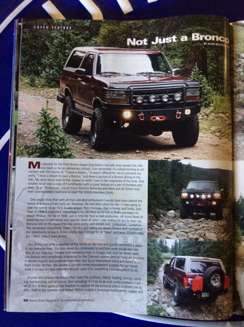 1996 Ford Bronco with aftermarket bumper and lights on a dirt road.