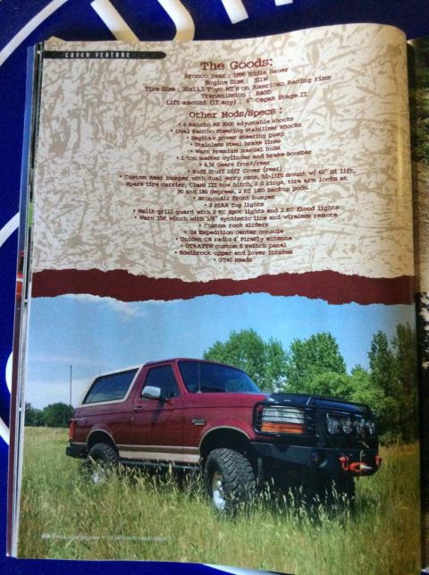 1996 Ford Bronco - A red 1996 Ford Bronco Eddie Bauer is parked in a grassy field with trees in the background. The vehicle is shown from a 3/4 front angle, h…
